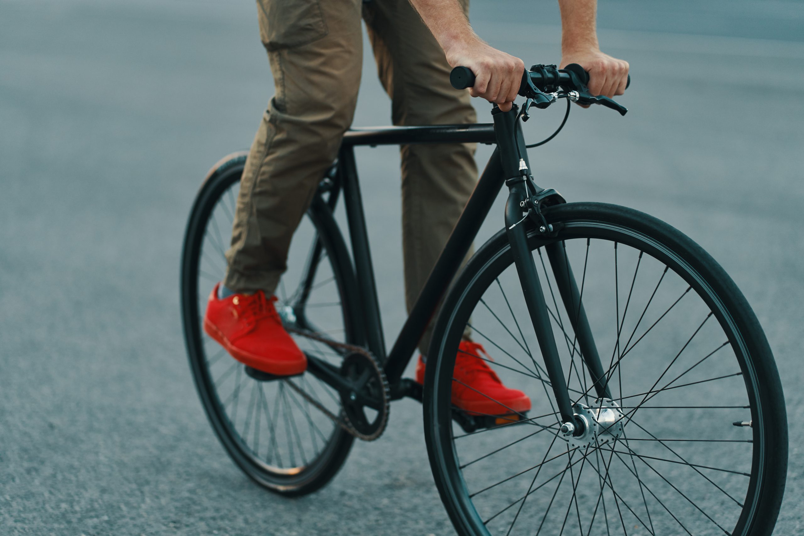 Closeup of casual man legs riding classic bike on city road